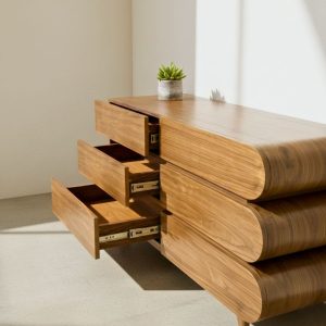 Commode design en bois clair avec tiroirs arrondis et décoration minimaliste